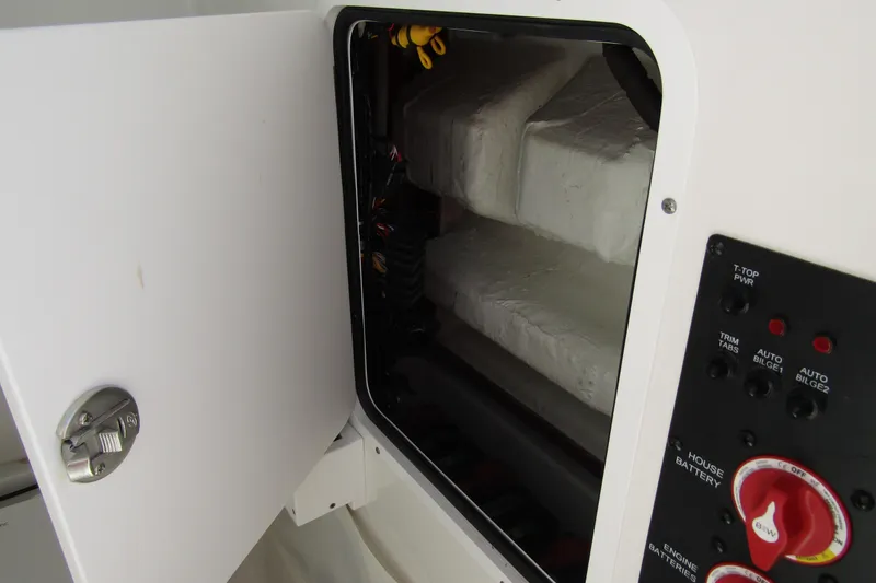 Slide: The Image of 2025 Sea Hunt Ultra 275 SE boat electrical panel and storage compartment. - 21