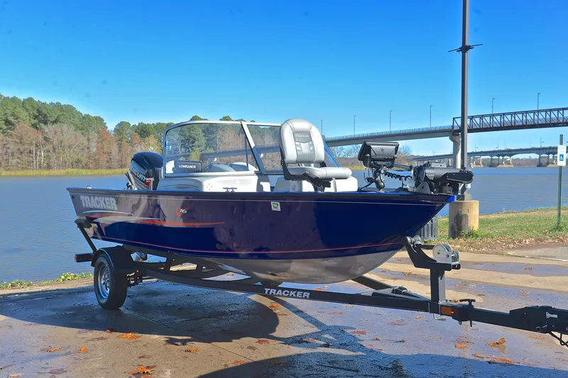 Slide: The Image of 2017 Tracker Pro Guide V-16 WT boat on trailer by a scenic river. - 16