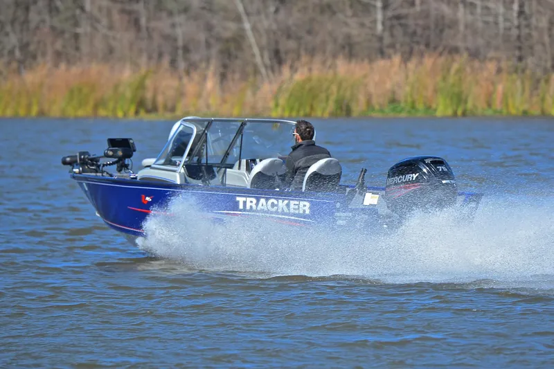 Slide: The Image of 2017 Tracker Pro Guide V-16 WT boat speeding on a lake with Mercury engine. - 4