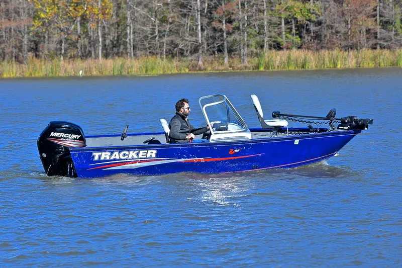 Slide: The Image of 2017 Tracker Pro Guide V-16 WT boat on a lake with a Mercury outboard motor. - 7