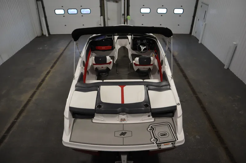 Slide: The Image of 2018 Four Winns H190 boat interior in a garage, featuring seating and steering wheel. - 10