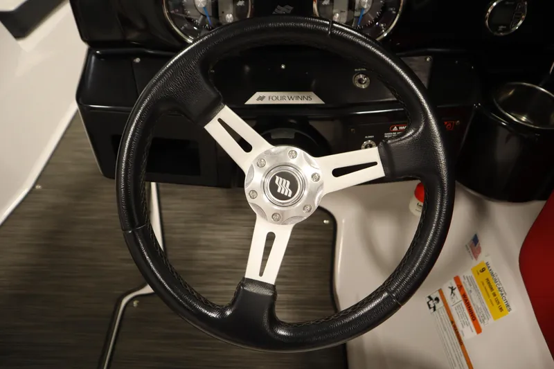 Slide: The Image of Steering wheel of 2018 Four Winns H190 boat, featuring sleek black and silver design. - 19