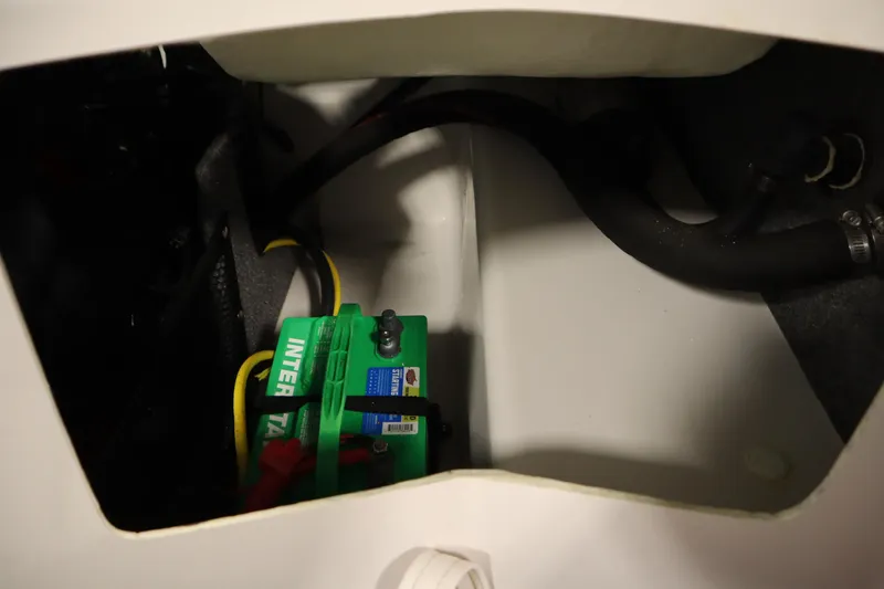 Slide: The Image of Battery compartment of 2018 Four Winns H190 boat, featuring green Interstate battery. - 38