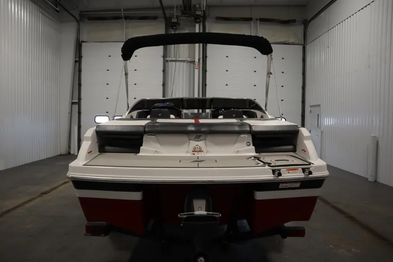 Slide: The Image of 2018 Four Winns H190 boat in a garage, rear view with bimini top. - 6