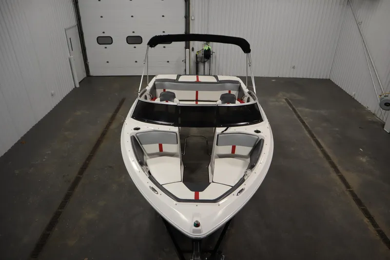 Slide: The Image of 2018 Four Winns H190 boat in indoor storage, featuring sleek design and spacious seating. - 9