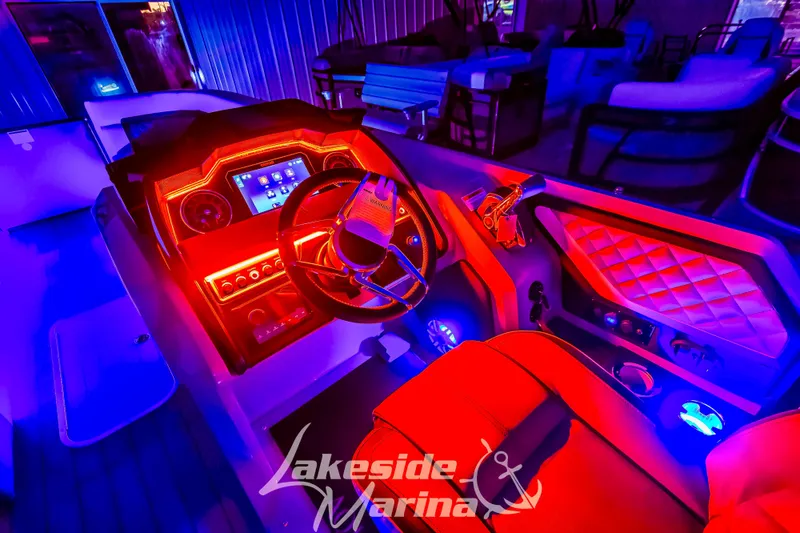 Slide: The Image of 2025 Godfrey AquaPatio 255 SBC boat interior with vibrant red and blue LED lighting. - 10