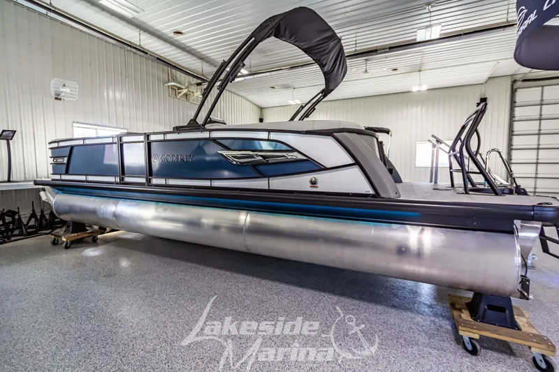 Slide: The Image of 2025 Godfrey AquaPatio 255 SBC pontoon boat in showroom, sleek design, Lakeside Marina. - 14