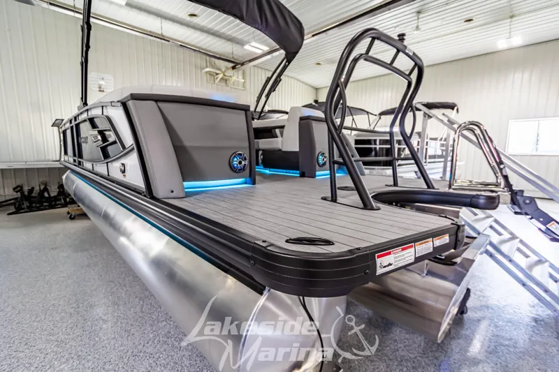Slide: The Image of 2025 Godfrey AquaPatio 255 SBC pontoon boat in showroom with sleek design and modern features. - 15