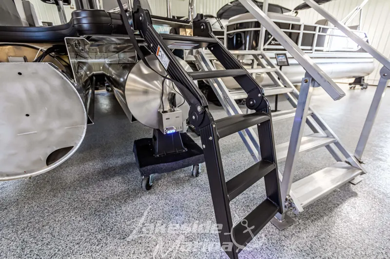 Slide: The Image of 2025 Godfrey AquaPatio 255 SBC pontoon boat with boarding ladder in showroom. - 16