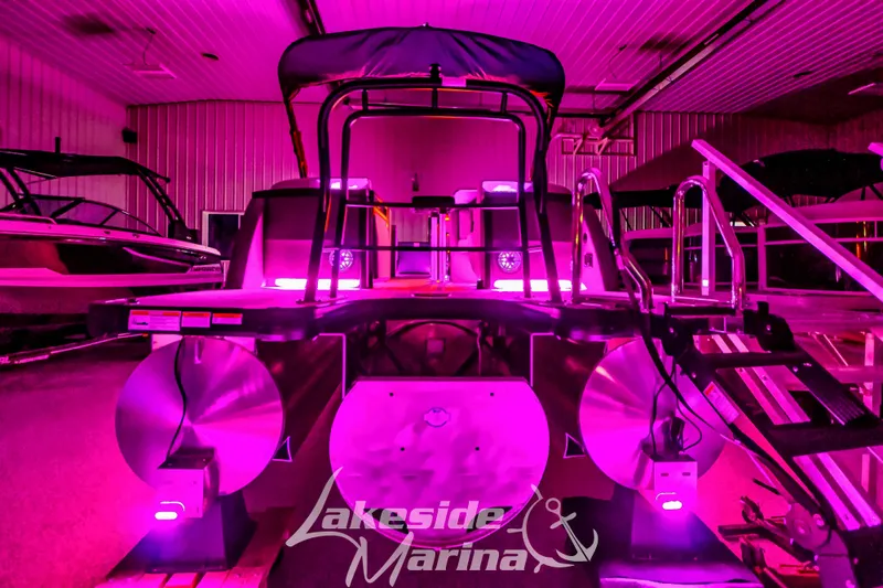 Slide: The Image of 2025 Godfrey AquaPatio 255 SBC pontoon boat with vibrant pink lighting at Lakeside Marina. - 3