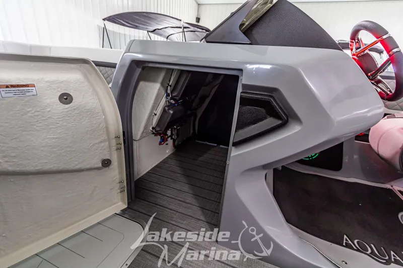Slide: The Image of 2025 Godfrey AquaPatio 255 SBC boat interior with open storage compartment. - 30