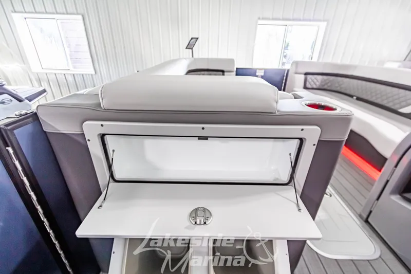 Slide: The Image of 2025 Godfrey AquaPatio 255 SBC interior with storage compartment in a marina setting. - 35
