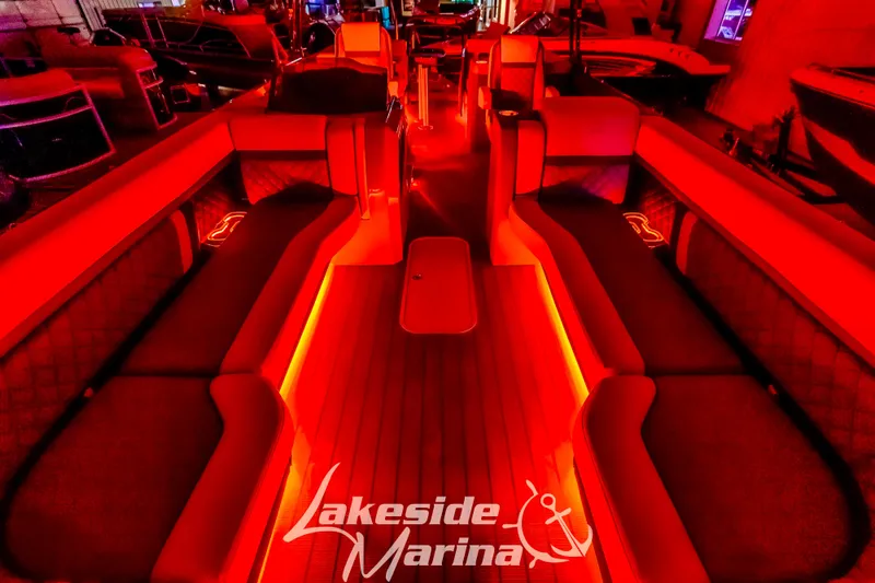 Slide: The Image of 2025 Godfrey AquaPatio 255 SBC boat interior with vibrant red lighting at Lakeside Marina. - 7