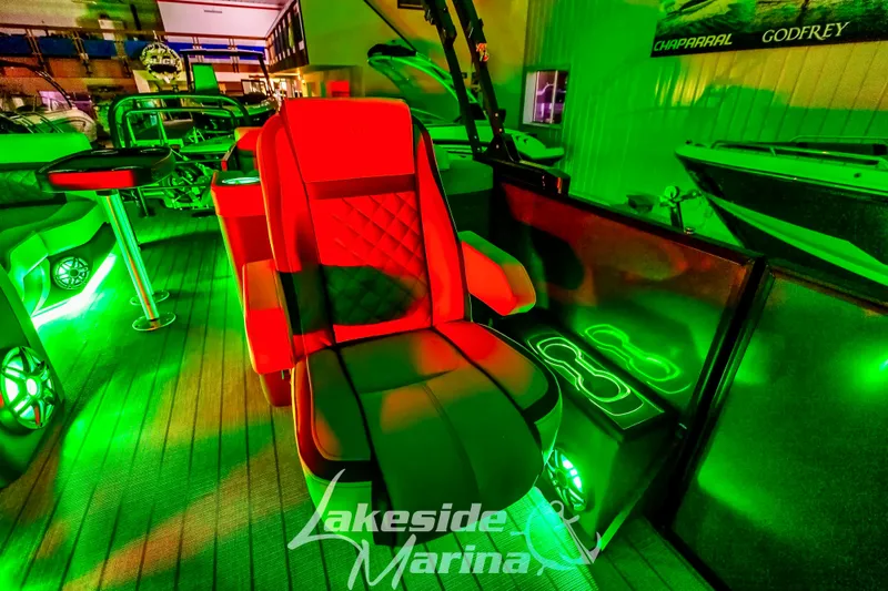 Slide: The Image of Luxurious 2025 Godfrey AquaPatio 255 SBC boat interior with vibrant green and red lighting. - 9