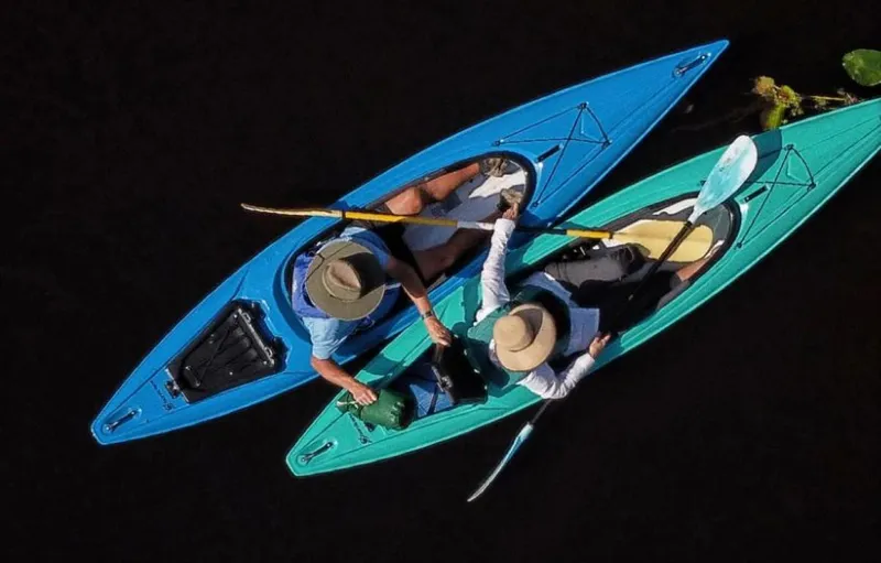 Slide: The Image of Two people kayaking in Hurricane Kayaks Prima 125 Sport, 2023 model, on a dark water surface. - 2