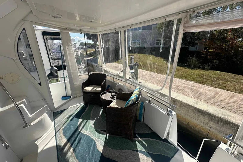 Slide: The Image of 2001 Carver 396 Motor Yacht interior with wicker chairs and scenic view. - 13
