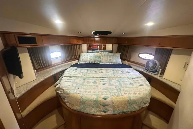 Slide: The Image of Luxurious bedroom in 2001 Carver 396 Motor Yacht with cozy bedding and elegant wood finish. - 24