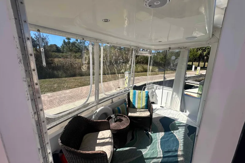 Slide: The Image of 2001 Carver 396 Motor Yacht interior with wicker chairs and striped cushions. - 12