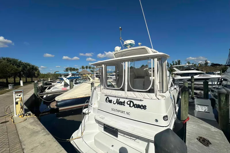 Slide: The Image of 2001 Carver 396 Motor Yacht docked in Southport, NC marina under clear blue sky. - 2