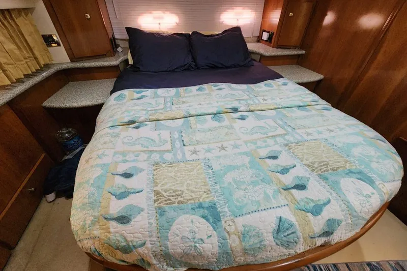 Slide: The Image of Cozy bedroom in 2001 Carver 396 Motor Yacht with nautical-themed bedding and warm lighting. - 25