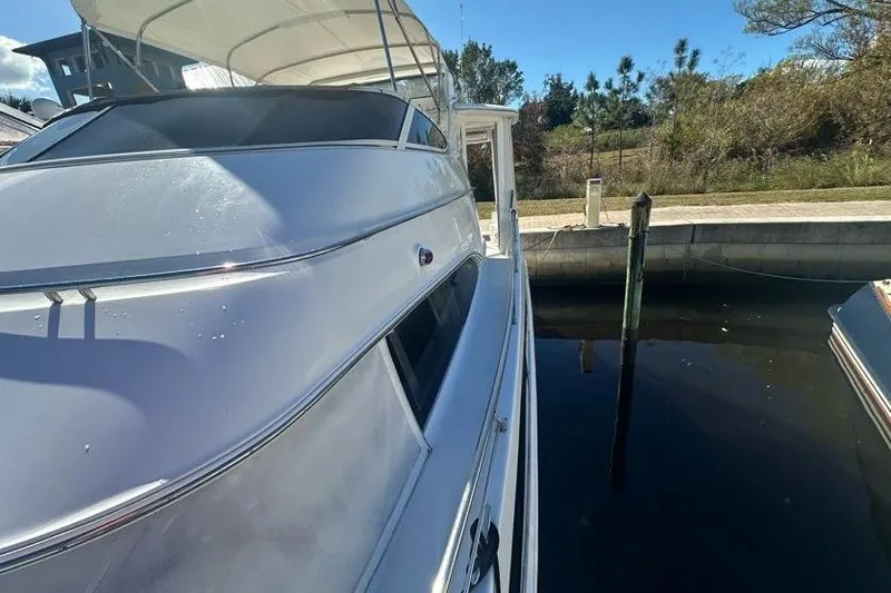 Slide: The Image of 2001 Carver 396 Motor Yacht docked in a serene marina setting. - 3