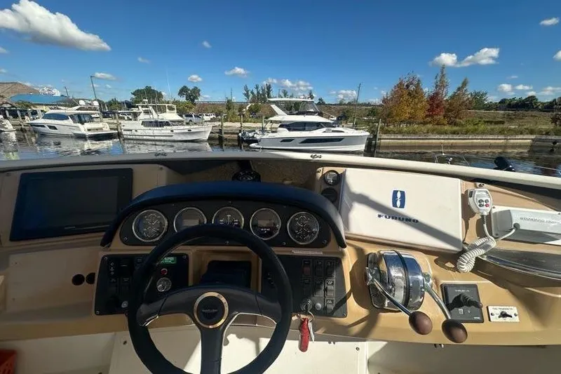 Slide: The Image of Helm of 2001 Carver 396 Motor Yacht with marina view, clear sky, and docked boats. - 5