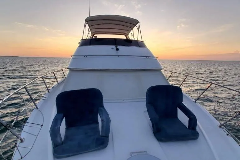 Slide: The Image of 2001 Carver 396 Motor Yacht at sunset, featuring two deck chairs on the bow. - 9