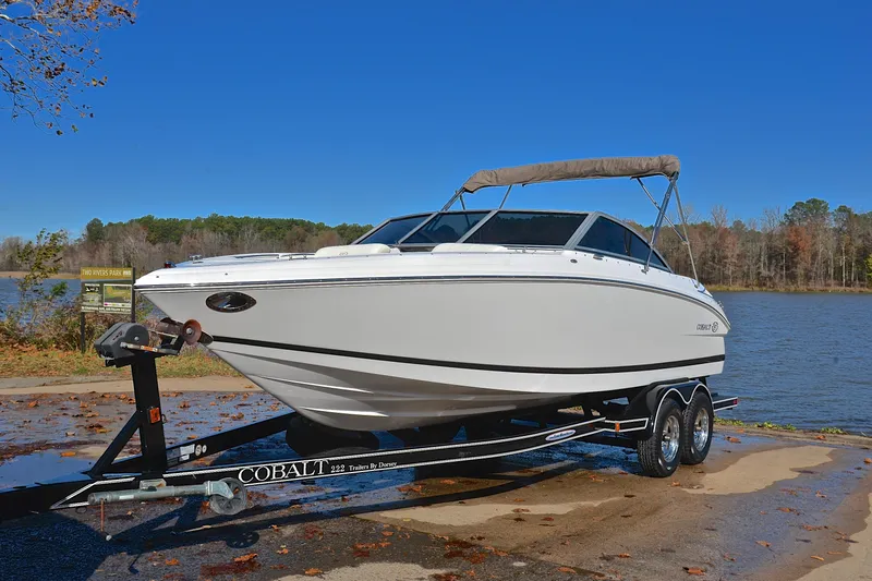 Slide: The Image of 2008 Cobalt 222 boat on trailer by a lake, clear blue sky. - 10