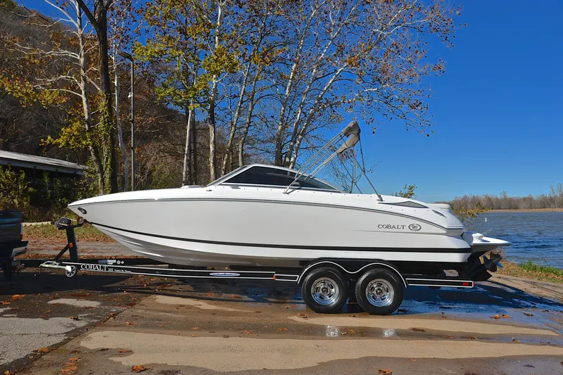 Slide: The Image of 2008 Cobalt 222 boat on trailer by a lake, surrounded by trees. - 11
