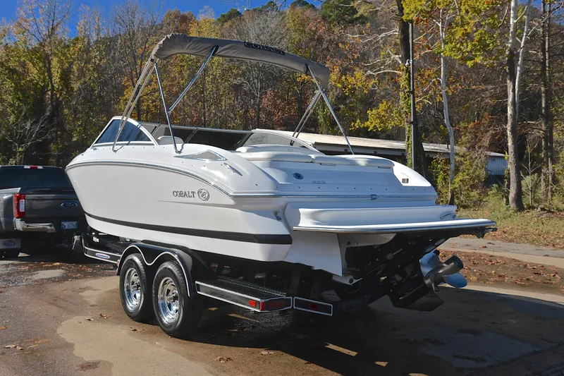 Slide: The Image of 2008 Cobalt 222 boat on trailer, parked outdoors with autumn trees in the background. - 12
