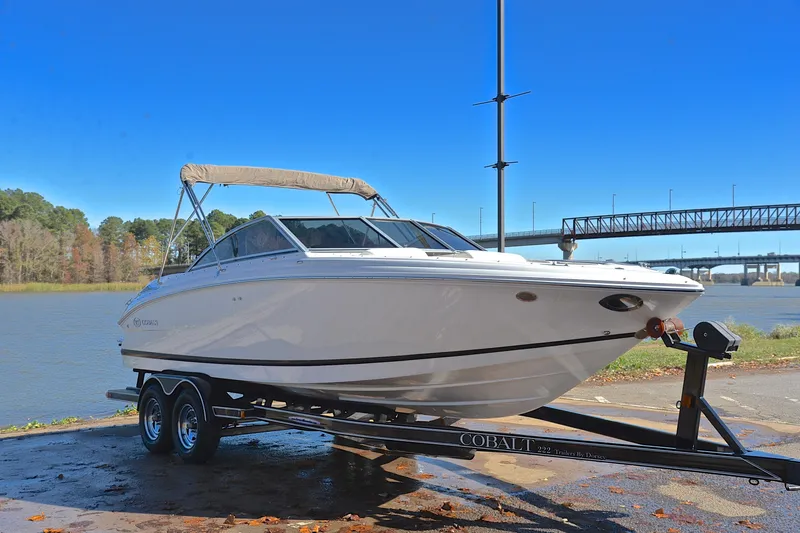 Slide: The Image of 2008 Cobalt 222 boat on trailer by river, clear blue sky background. - 16