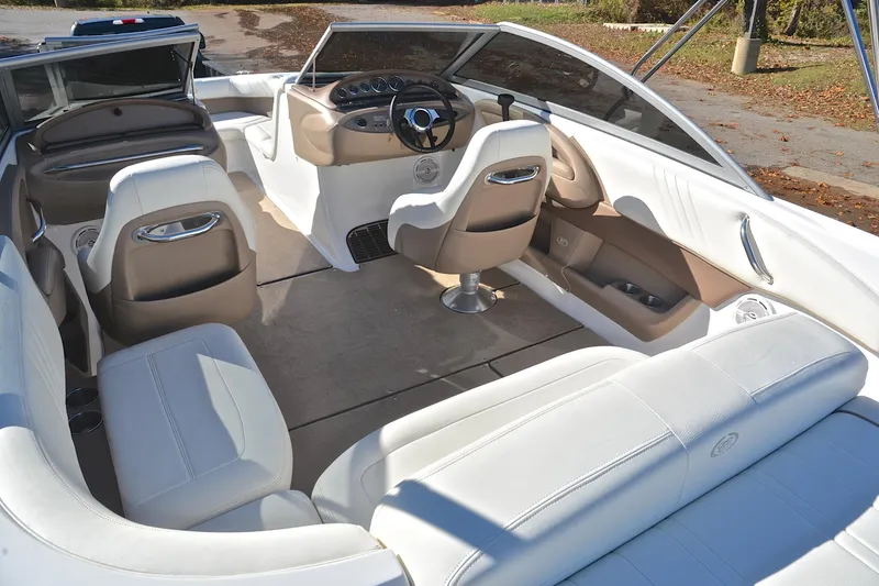Slide: The Image of 2008 Cobalt 222 boat interior with white and beige seating, steering wheel, and dashboard. - 23