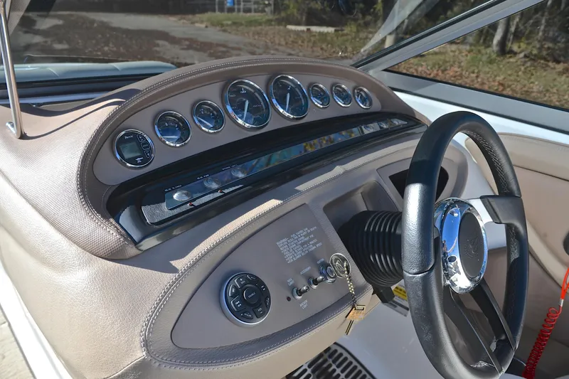 Slide: The Image of 2008 Cobalt 222 boat dashboard with gauges and steering wheel in sunlight. - 26