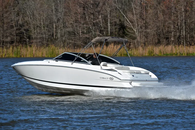 Slide: The Image of 2008 Cobalt 222 boat cruising on a lake with forested background. - 4
