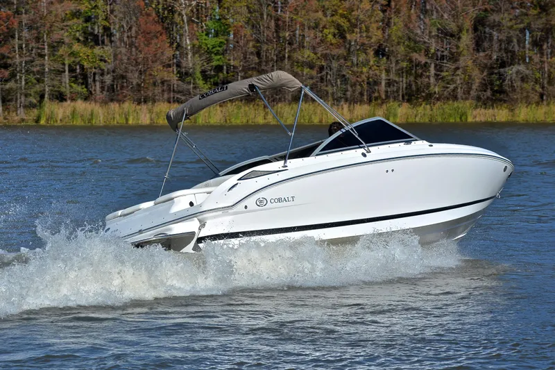 Slide: The Image of 2008 Cobalt 222 boat cruising on a lake with forested background. - 5