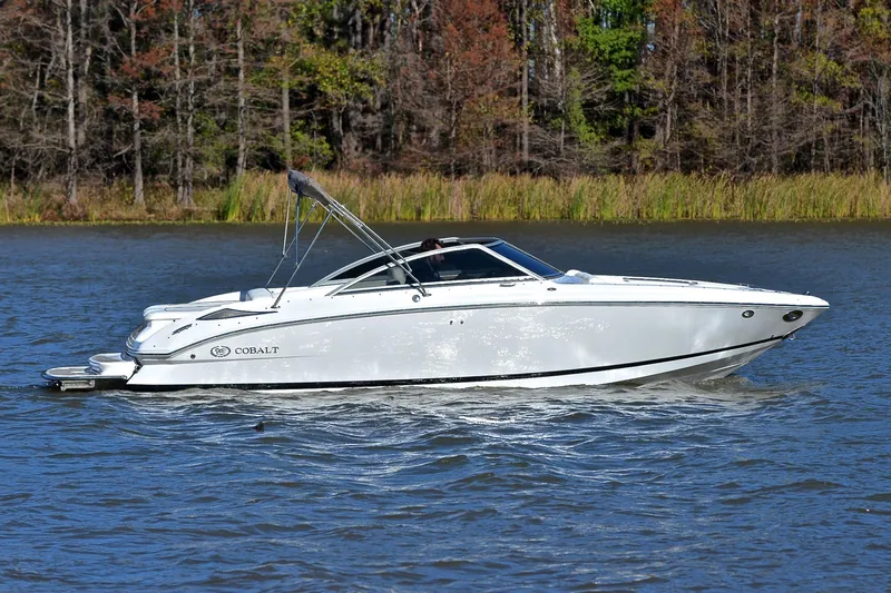 Slide: The Image of 2008 Cobalt 222 boat cruising on a lake with forested shoreline. - 7