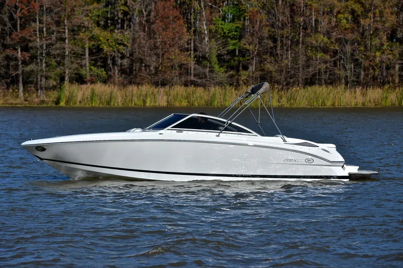 Slide: The Image of 2008 Cobalt 222 boat cruising on a lake with forested background. - 9