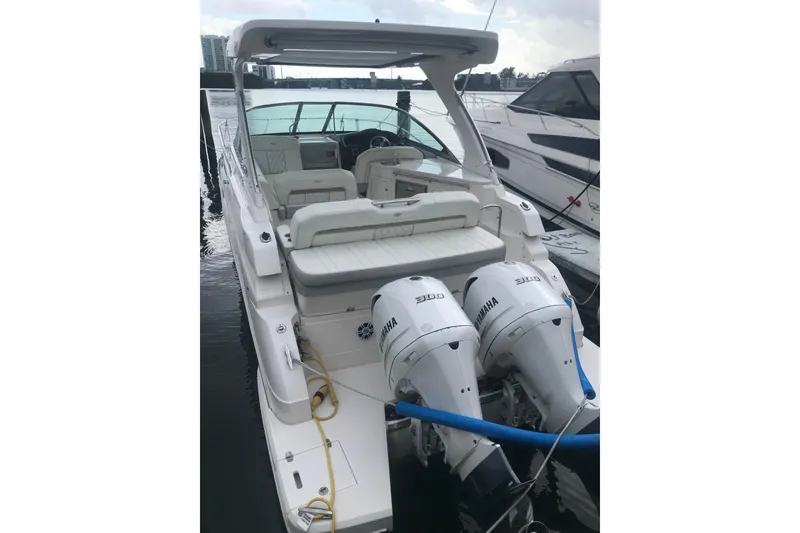 Slide: The Image of 2021 Regal 33 XO boat docked at marina with modern buildings in background. - 3