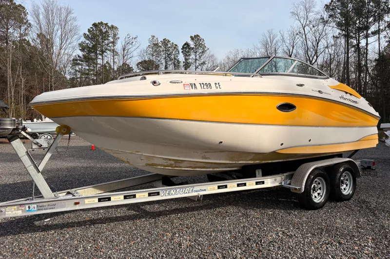 The Image of 2008 Hurricane SunDeck 2000 OB boat on trailer, yellow and white, parked outdoors. - 0