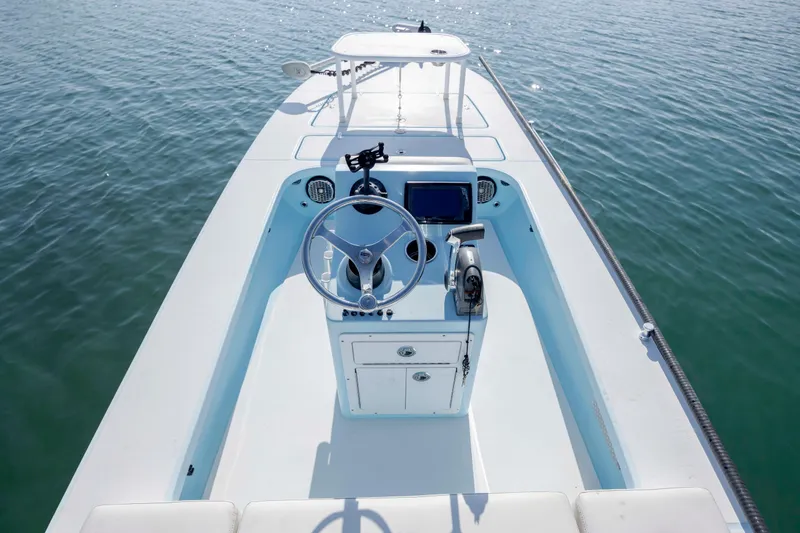 Slide: The Image of 2015 East Cape Fury boat interior with steering wheel and control panel on calm water. - 13