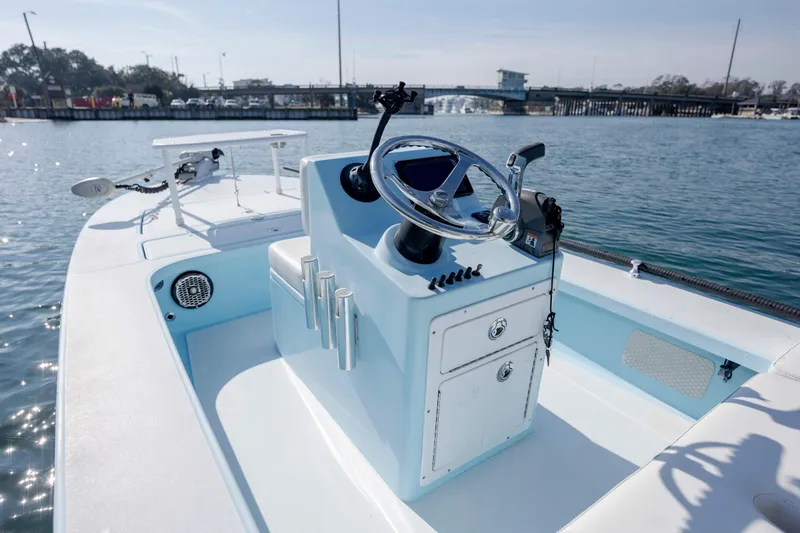 Slide: The Image of 2015 East Cape Fury boat interior with steering wheel, on calm water near a bridge. - 14