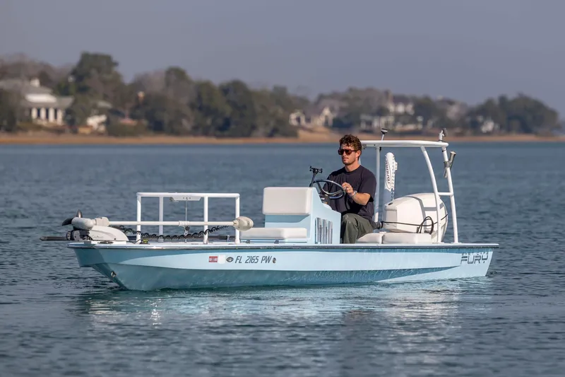 Slide: The Image of Man driving 2015 East Cape Fury boat on calm water. - 3