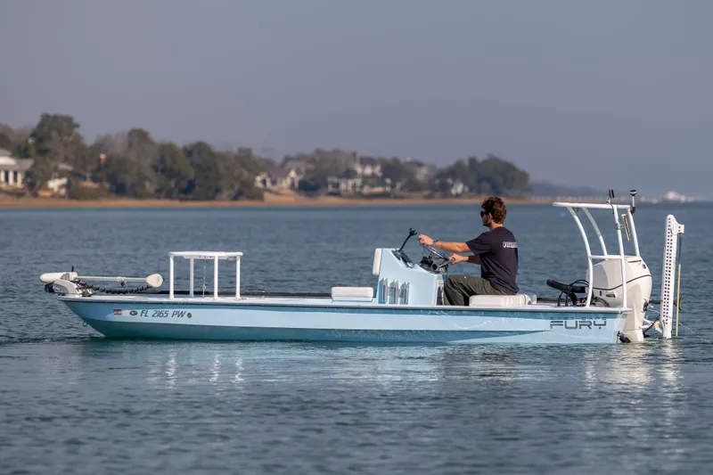 Slide: The Image of 2015 East Cape Fury boat on calm water with driver, scenic shoreline in background. - 4