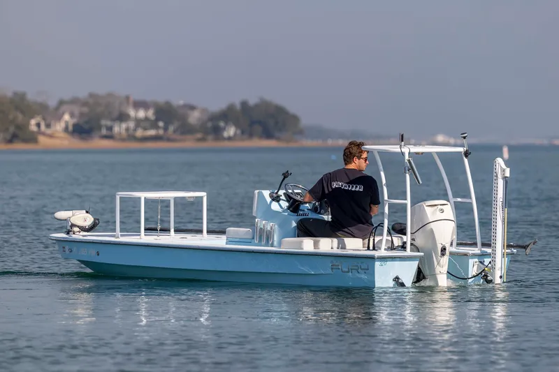 Slide: The Image of 2015 East Cape Fury boat on calm water, with driver, near shoreline. - 5