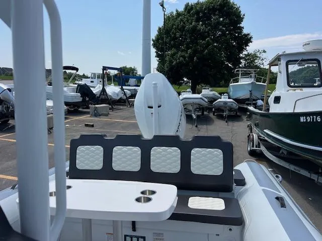 Slide: The Image of 2024 Highfield Sport 800 boat interior with seating and cup holders, parked among other boats. - 11