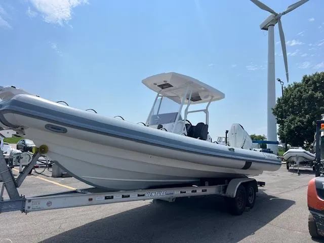 Slide: The Image of 2024 Highfield Sport 800 boat on trailer near wind turbine, under clear sky. - 16
