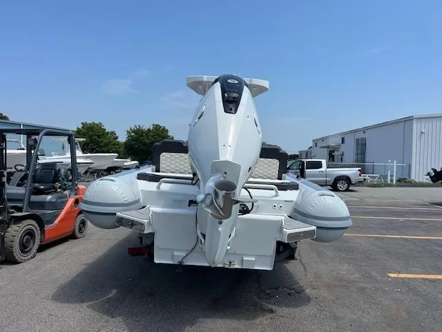 Slide: The Image of 2024 Highfield Sport 800 boat parked outdoors, rear view, with industrial background. - 4