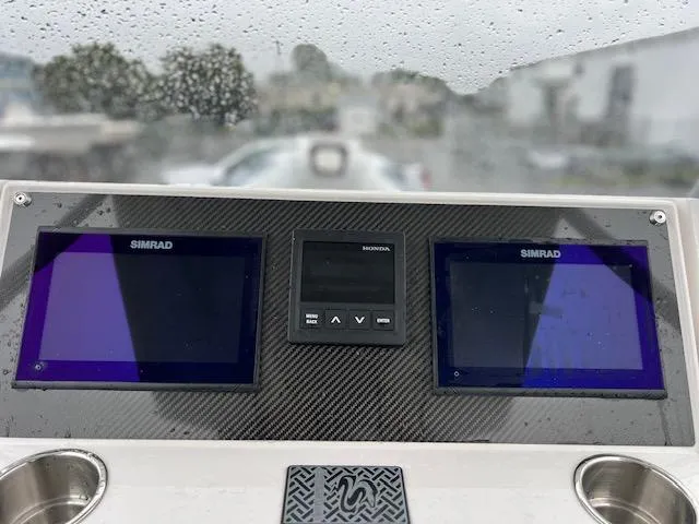 Slide: The Image of Dashboard of 2024 Highfield Sport 800 boat with Simrad displays in rainy weather. - 7
