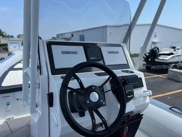 Slide: The Image of 2024 Highfield Sport 800 boat dashboard with Simrad navigation system and steering wheel. - 8
