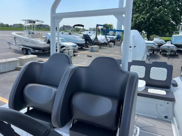 Slide: The Image of 2024 Highfield Sport 800 boat interior with dual seats, parked in a marina. - 9